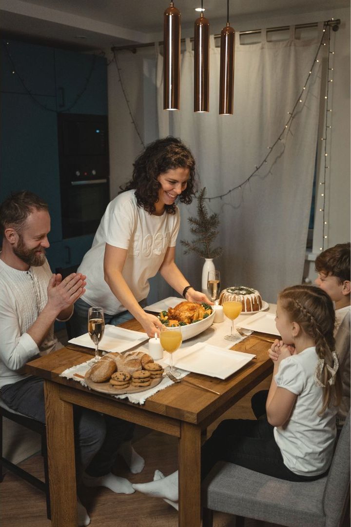 Una familia se sienta alrededor de una mesa y come.